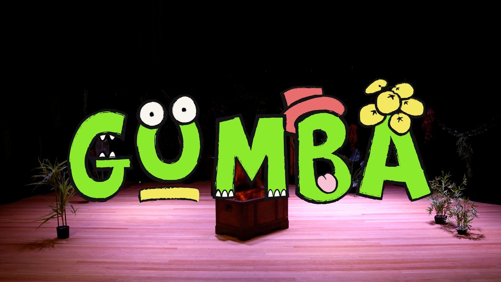 The Gumba logo built as a glowing stage sign, framed by jungle greenery and stage lights.